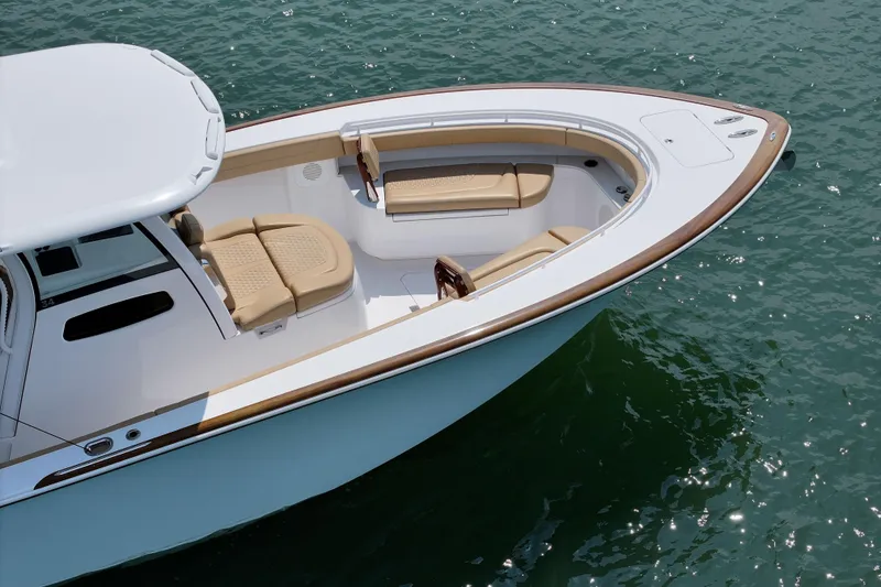 Slide: The Image of 2023 Phenom 34 boat with sleek design and comfortable seating on calm water. - 14