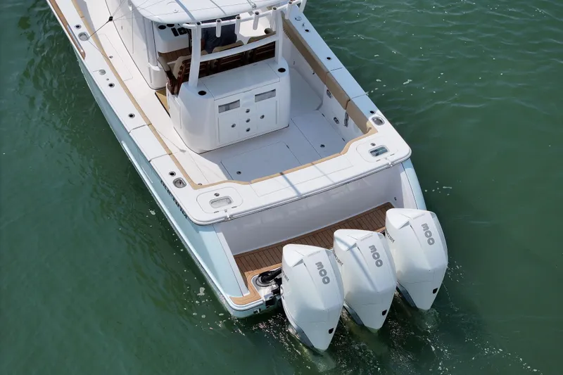 Slide: The Image of 2023 Phenom 34 boat with triple outboard engines on water. - 12