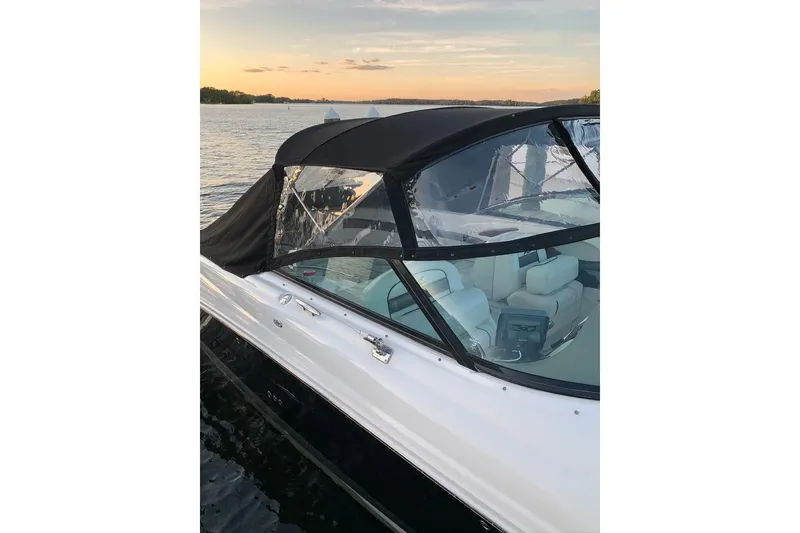 Slide: The Image of 2005 Sea Ray 290 SLX boat with canopy on calm water at sunset. - 3