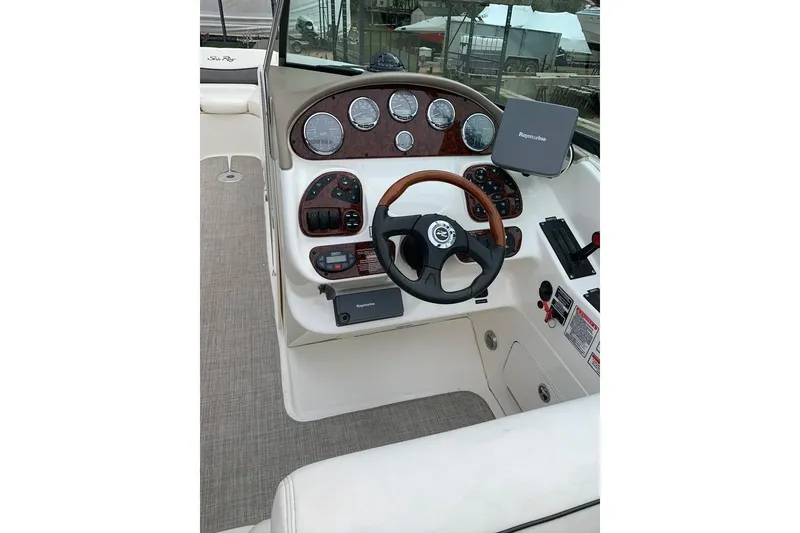 Slide: The Image of 2005 Sea Ray 290 SLX boat dashboard with steering wheel and navigation instruments. - 16