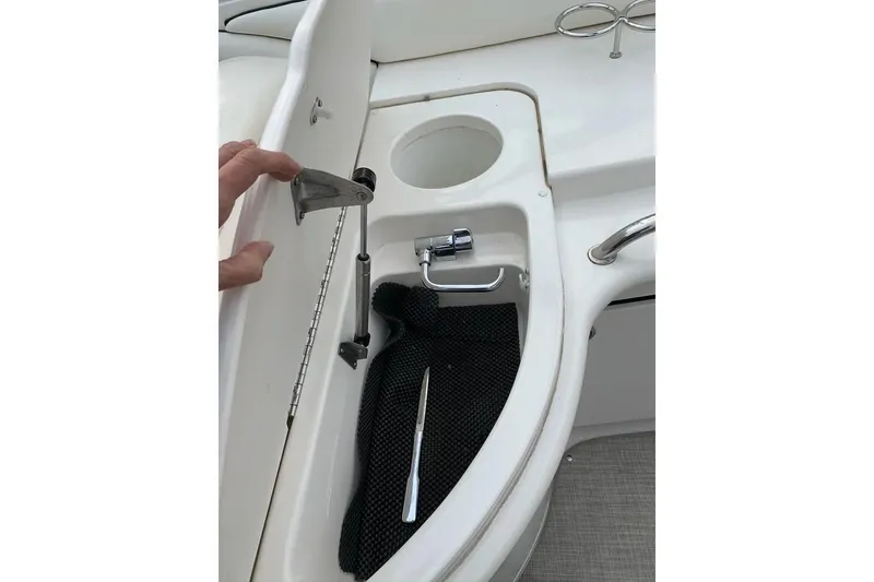 Slide: The Image of 2005 Sea Ray 290 SLX boat interior with storage compartment and cup holder. - 9