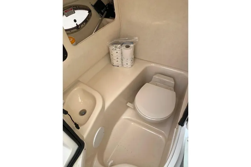 Slide: The Image of 2005 Sea Ray 290 SLX boat bathroom with toilet, sink, and toilet paper. - 19