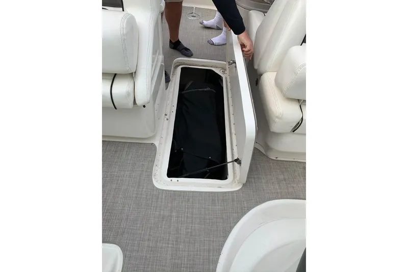 Slide: The Image of 2005 Sea Ray 290 SLX boat interior with open storage compartment and white seating. - 11
