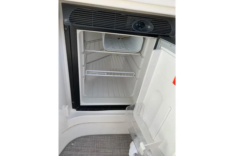 Slide: The Image of Open refrigerator inside a 2005 Sea Ray 290 SLX boat, showing empty shelves. - 10