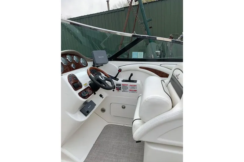 Slide: The Image of 2005 Sea Ray 290 SLX boat cockpit with steering wheel and control panel. - 17
