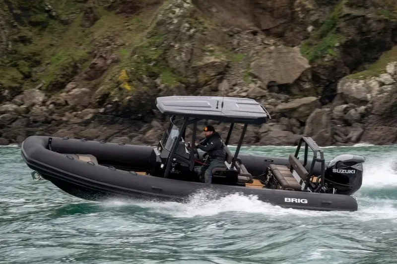 The Image of Manufacturer Provided Image: 2026 Brig Navigator 26 boat navigating through waves near rocky coastline. - 0