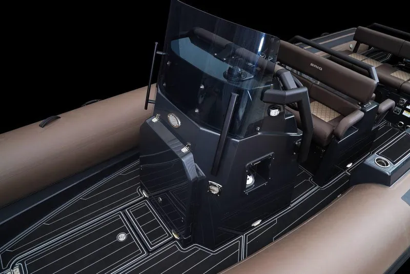 Slide: The Image of 2027 Brig Navigator 26 boat interior with sleek black console and brown seating. - 6