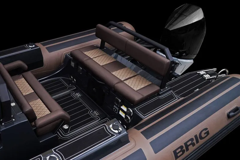 Slide: The Image of 2027 Brig Navigator 26 boat interior with brown seating and sleek design. - 4