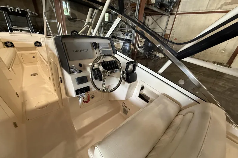 Slide: The Image of 2021 Grady-White Freedom 275 boat interior with Garmin navigation system and steering wheel. - 5