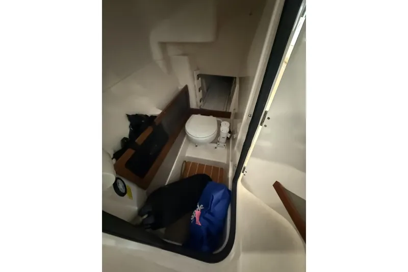 Slide: The Image of 2021 Grady-White Freedom 275 boat interior with compact toilet and storage area. - 6