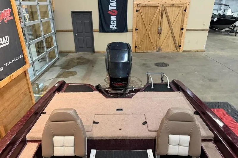 Slide: The Image of 1997 Astro 2050 FSX boat interior with dual seats and Mercury outboard motor in a showroom. - 7