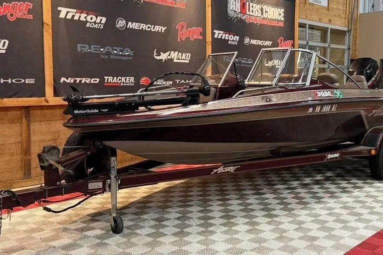 Slide: The Image of 1997 Astro 2050 FSX boat on display in showroom with branded backdrop. - 5