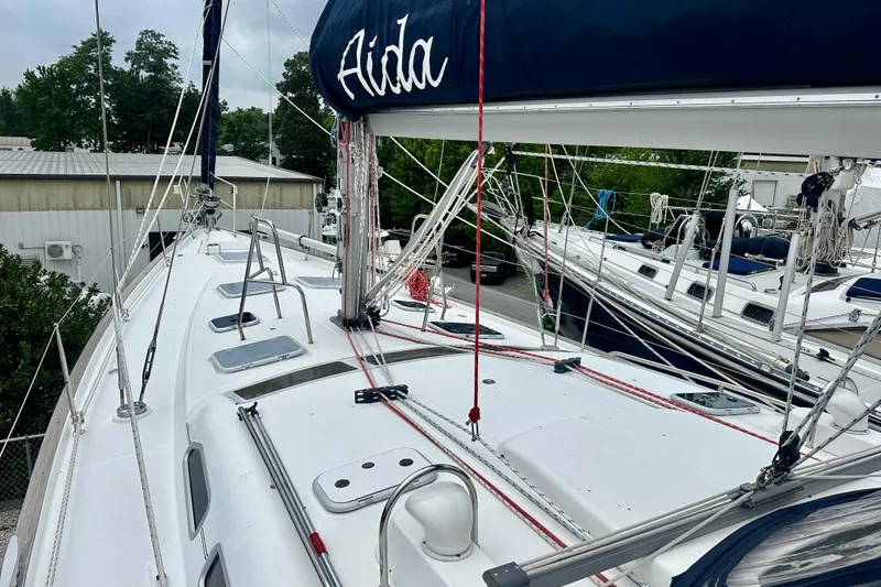 Slide: The Image of 2002 Beneteau Oceanis Clipper 473 sailboat deck with rigging and hatches, docked in a marina. - 16