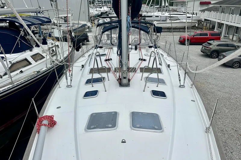 Slide: The Image of 2002 Beneteau Oceanis Clipper 473 sailboat docked in a marina, surrounded by other boats. - 17