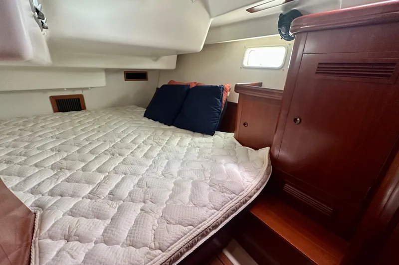 Slide: The Image of Cozy cabin interior of 2002 Beneteau Oceanis Clipper 473 sailboat with bed and wooden cabinetry. - 30