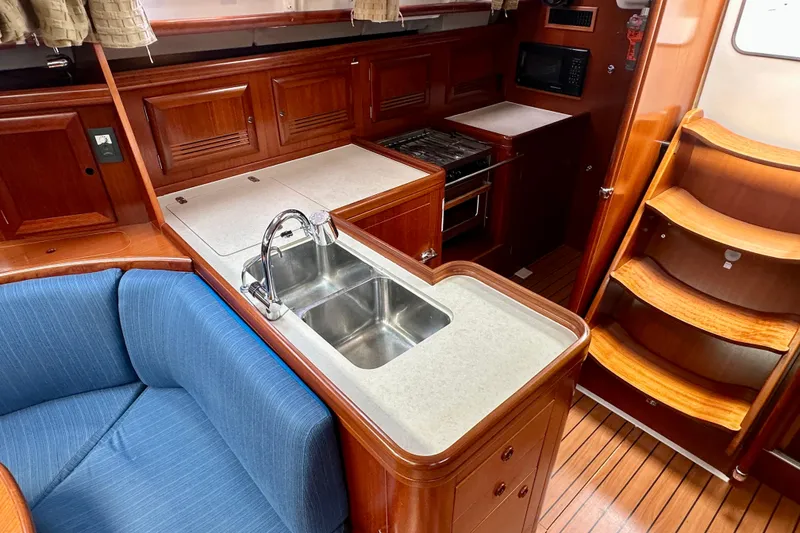 Slide: The Image of Interior of 2002 Beneteau Oceanis Clipper 473 yacht with kitchen and seating area. - 25