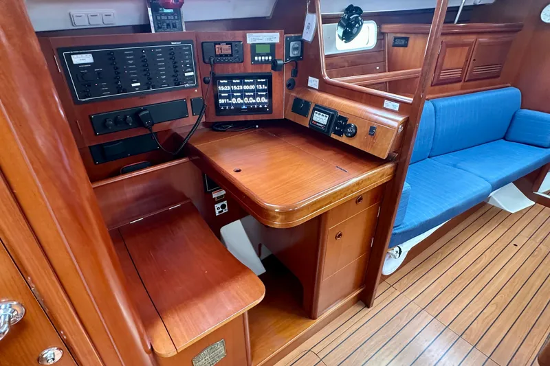 Slide: The Image of Interior of 2002 Beneteau Oceanis Clipper 473 yacht with navigation station and blue seating. - 21