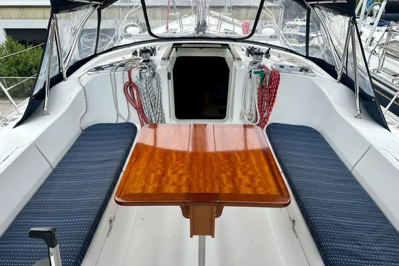 Slide: The Image of Cockpit of 2002 Beneteau Oceanis Clipper 473 with wooden table and blue seating. - 15