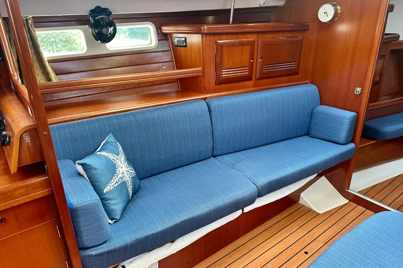 Slide: The Image of Interior of 2002 Beneteau Oceanis Clipper 473 with blue seating and wooden cabinetry. - 23