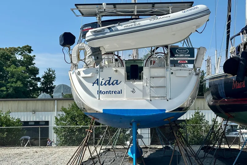 Slide: The Image of Beneteau Oceanis Clipper 473 sailboat from 2002 on dry dock, featuring a dinghy. - 8