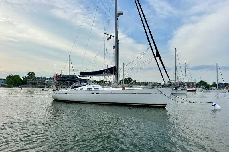 Slide: The Image of 2002 Beneteau Oceanis Clipper 473 sailboat anchored in a serene marina setting. - 4