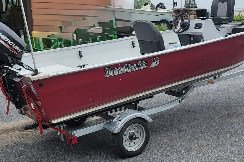 Slide: The Image of Red 2023 Duranautic V-16 boat on trailer, featuring Mercury outboard motor. - 11