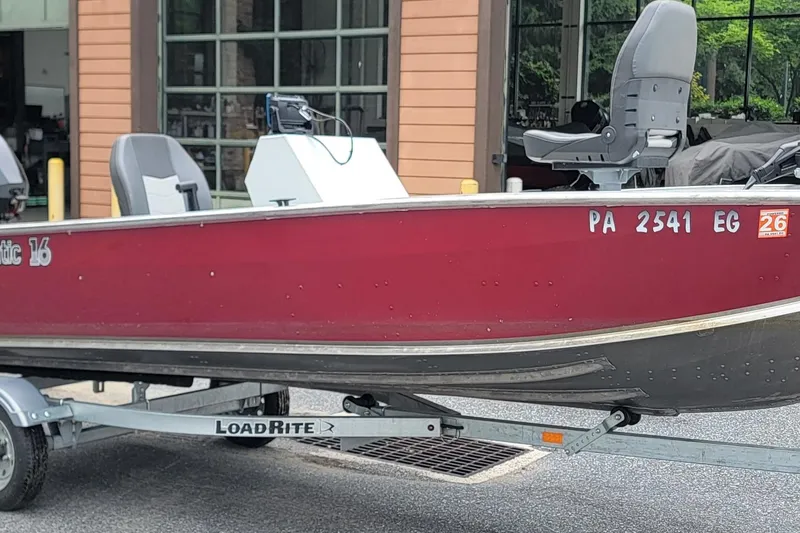 Slide: The Image of 2023 Duranautic V-16 boat on LoadRite trailer, red exterior, parked outside a building. - 0