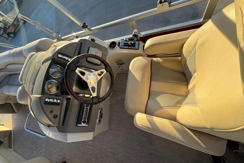 Slide: The Image of Captain's seat and helm of a 2010 Bennington 2375RL pontoon boat. - 12