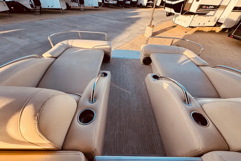 Slide: The Image of Luxurious seating on a 2010 Bennington 2375RL pontoon boat, featuring cup holders and armrests. - 18