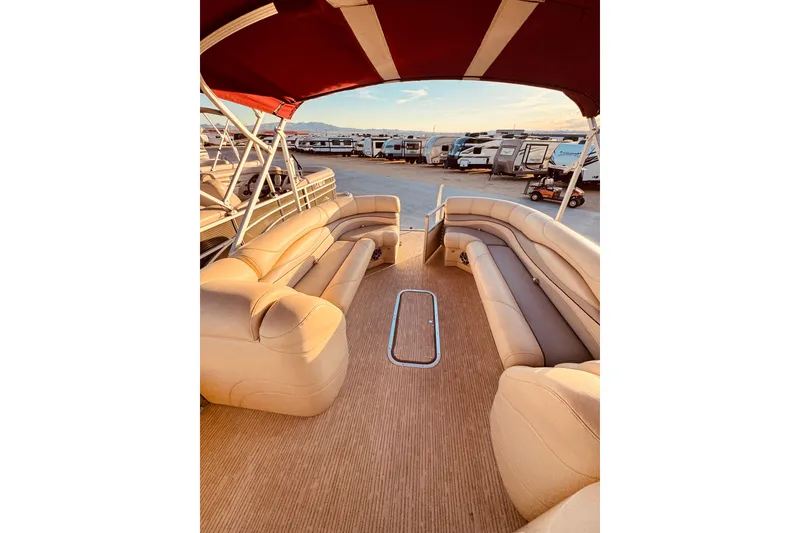 Slide: The Image of 2010 Bennington 2375RL pontoon boat interior with beige seating and red canopy. - 10