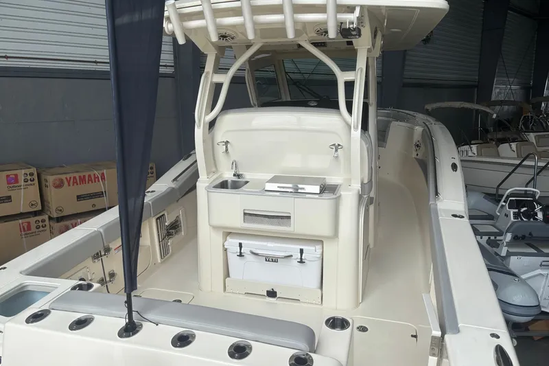 Slide: The Image of 2026 Scout 330 LXF boat interior with sink and storage, displayed indoors. - 8