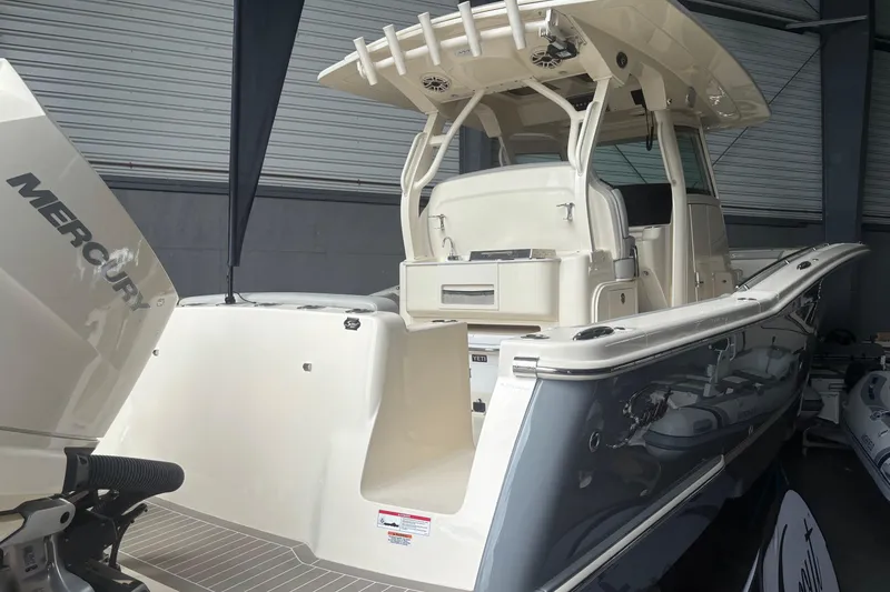 Slide: The Image of 2026 Scout 330 LXF boat with Mercury engine in showroom. - 3