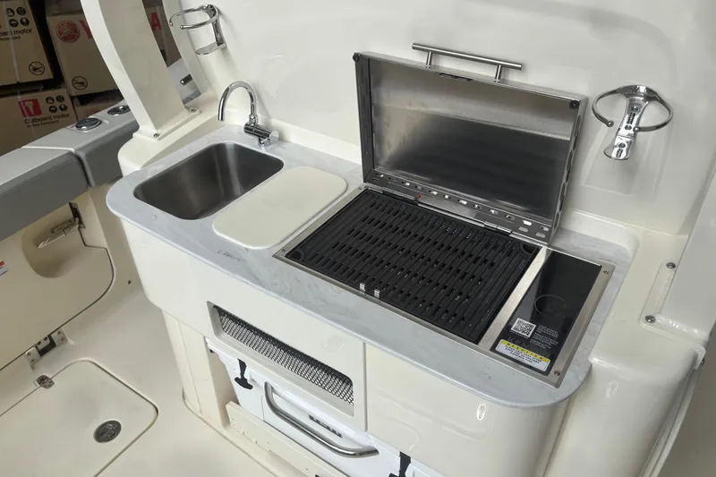 Slide: The Image of 2026 Scout 330 LXF boat kitchen with sink and grill setup. - 9