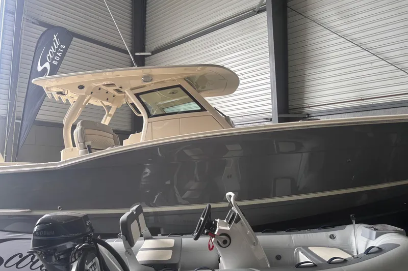 Slide: The Image of 2026 Scout 330 LXF boat displayed indoors with Yamaha engine in foreground. - 4