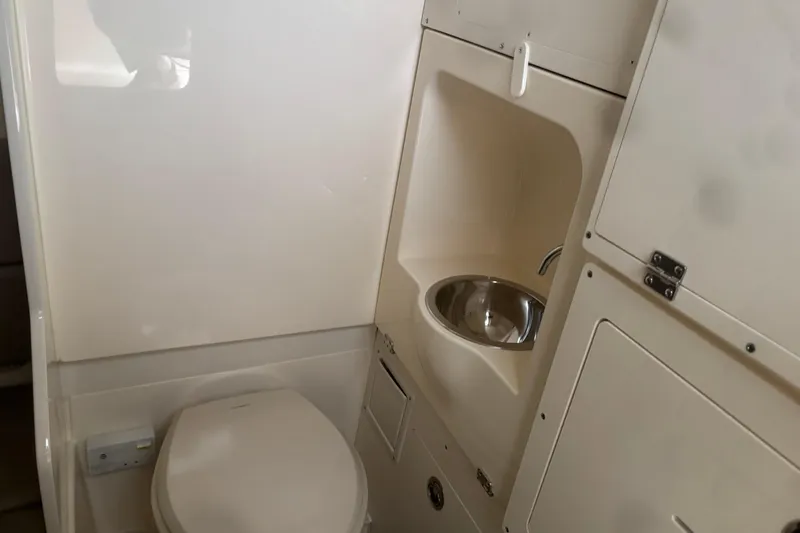 Slide: The Image of Compact bathroom in 2026 Scout 330 LXF boat with toilet and sink. - 26
