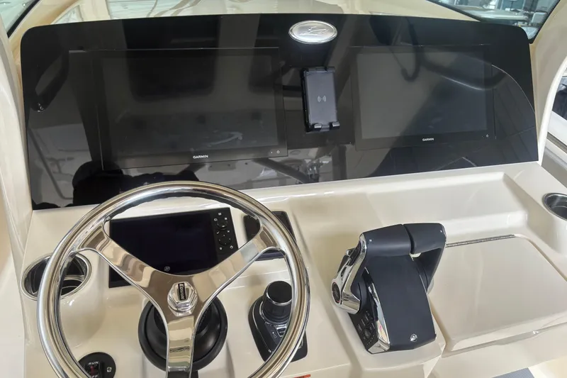 Slide: The Image of 2026 Scout 330 LXF boat dashboard with steering wheel and Garmin displays. - 13