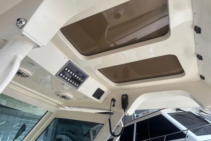Slide: The Image of Interior view of 2026 Scout 330 LXF boat, featuring control panel and sunroof. - 14