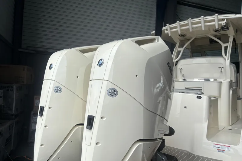 Slide: The Image of 2026 Scout 330 LXF boat with dual Mercury outboard engines in a storage facility. - 6