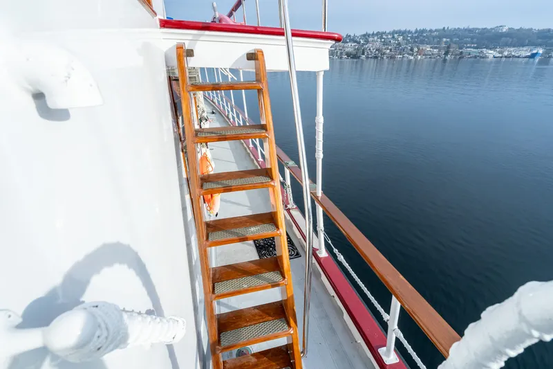 Slide: The Image of Wooden stairs on 1941 Custom Sagstad Fantail boat, overlooking calm water and distant shoreline. - 17