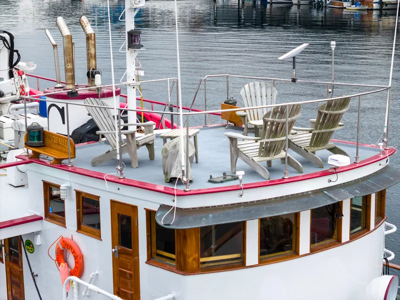 Slide: The Image of 1941 Custom Sagstad Fantail boat with deck chairs, docked on calm water. - 13