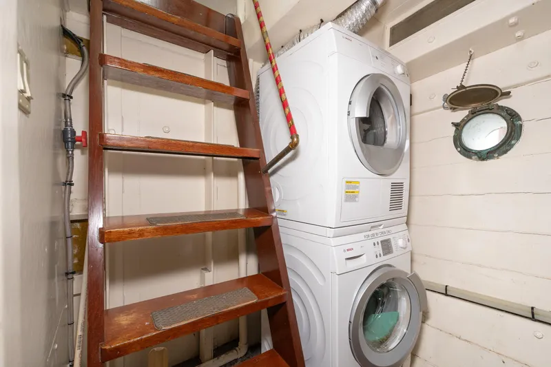 Slide: The Image of Interior of a boat with wooden stairs and a washing machine. - 59