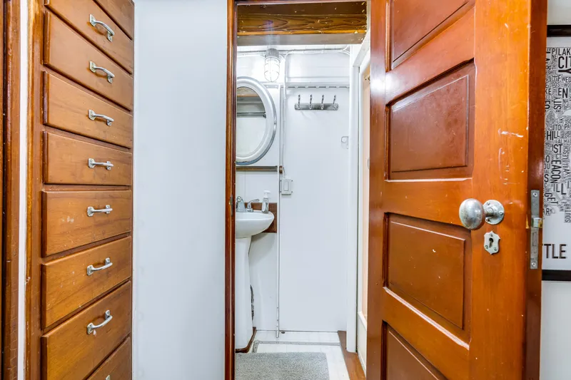 Slide: The Image of Interior of a boat with wooden doors and cabinets, sink, and mirror. - 51
