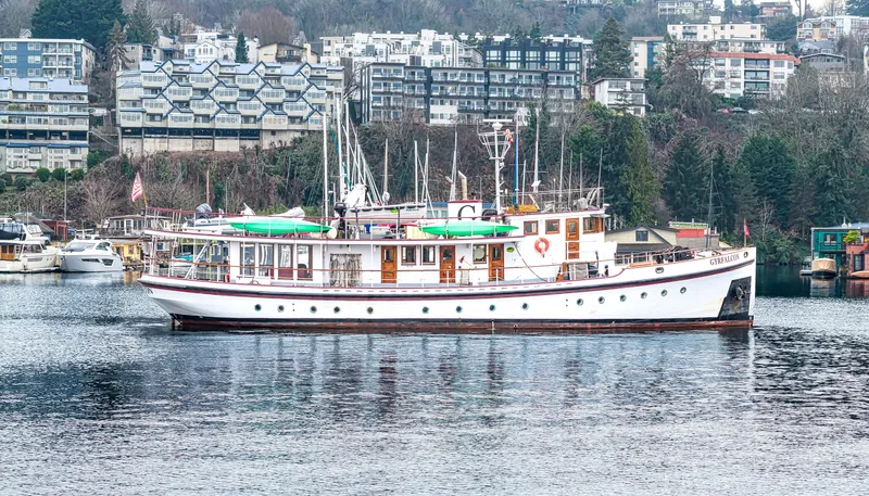 Slide: The Image of Vintage 1941 Custom Sagstad Fantail yacht on a calm waterfront with urban backdrop. - 14