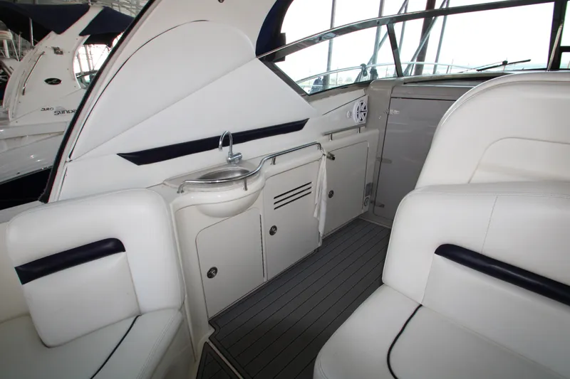 Slide: The Image of Interior of 2008 Sea Ray 38 Sundancer yacht with white seating and compact kitchenette. - 12