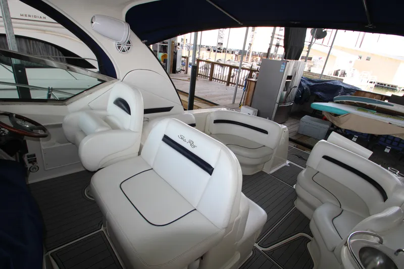 Slide: The Image of 2008 Sea Ray 38 Sundancer interior with white seating and helm, docked at marina. - 15