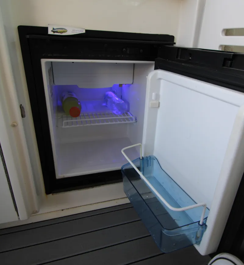 Slide: The Image of Open mini fridge on 2008 Sea Ray 38 Sundancer boat, interior lit with blue light. - 13