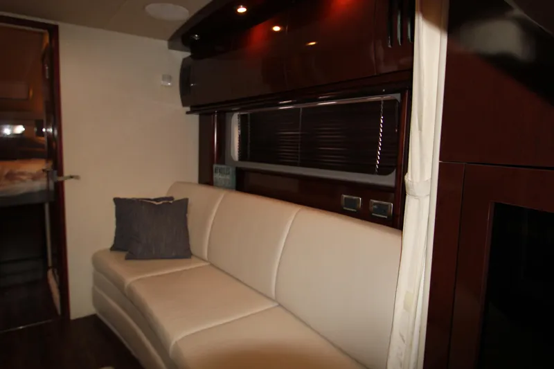 Slide: The Image of Interior of 2008 Sea Ray 38 Sundancer with cream sofa and dark wood accents. - 36