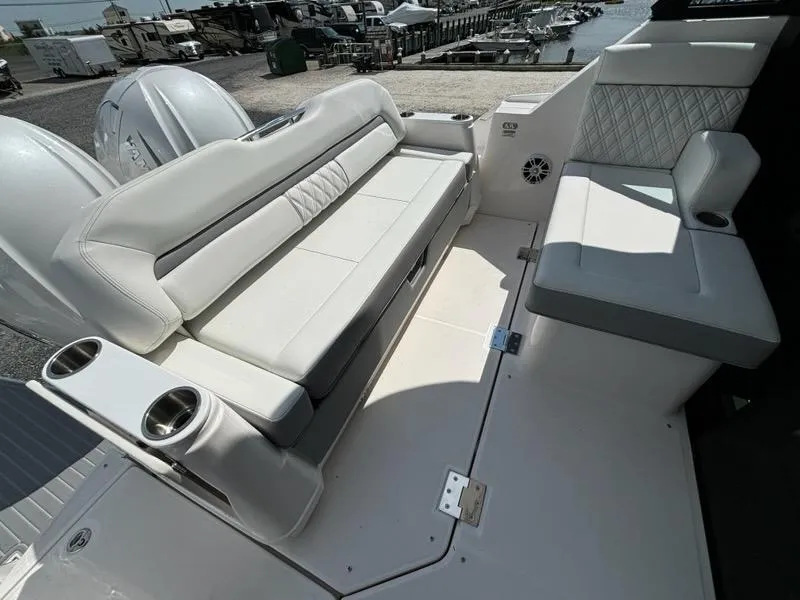 Slide: The Image of Luxurious seating on 2025 Regal 36 XO boat, featuring white leather upholstery and cup holders. - 33
