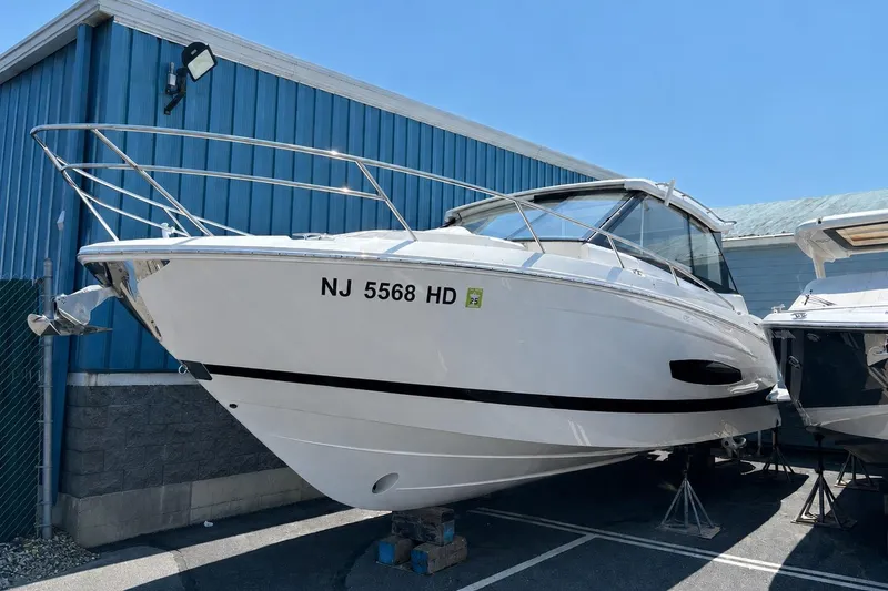 Slide: The Image of 2026 Regal 36 XO boat in storage, white hull, docked outdoors. - 62