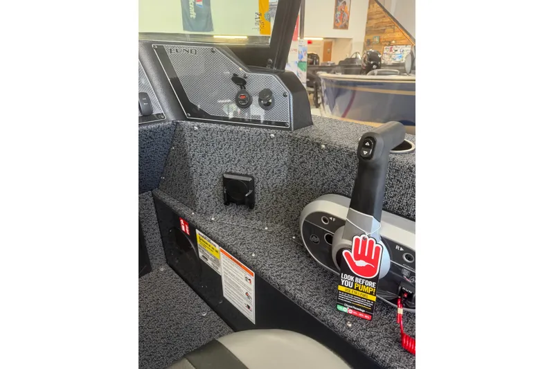 Slide: The Image of Interior of 2027 Lund 1700 Explorer Sport boat with control panel and safety warning. - 13